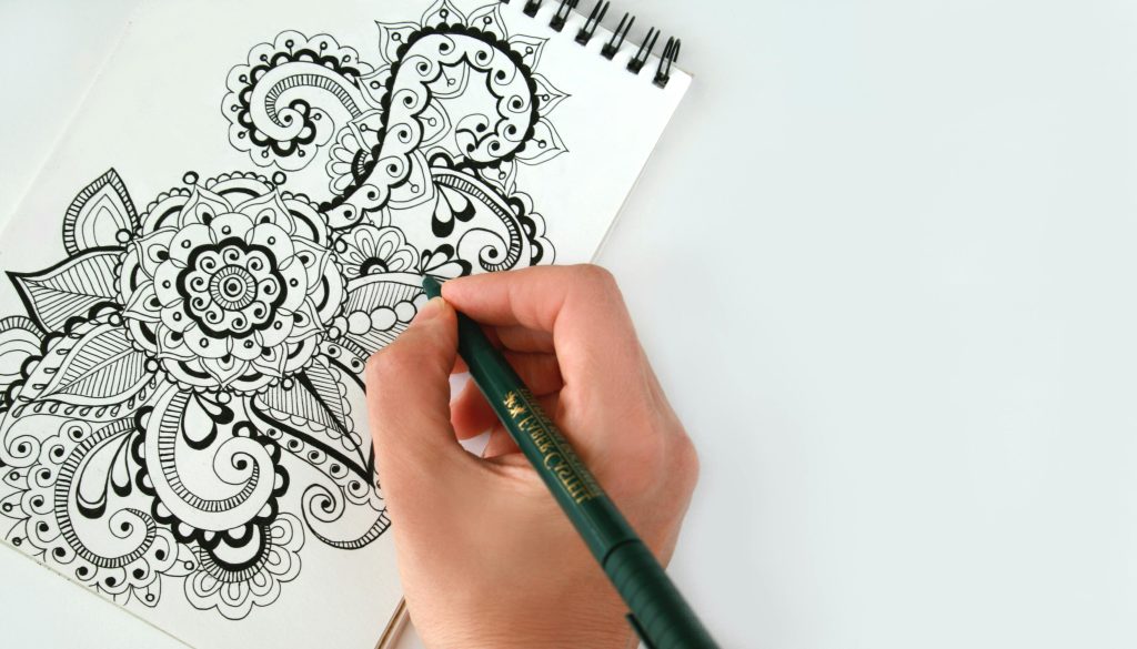 An artist's hand holding a pencil as they add fine details to their drawing. Detail is one of the steps in learning easy steps on how to draw.